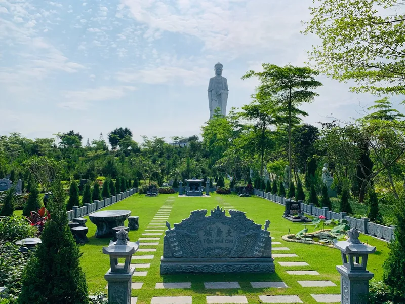 Khuôn viên gia đình có cuốn thư đá và đèn đá, phía xa là tượng A Di Đà tại Công viên Thiên Đức