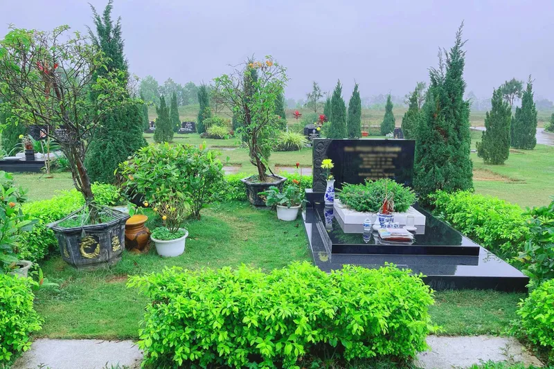Mộ đơn đá granite đen trong khuôn viên cỏ tại Công viên Thiên Đức